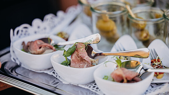 Fein angerichtete Häppchen und Snacks mit Schinken, Sprossen und Oliven als Catering eines Firmenevents auf Gut Wöllried