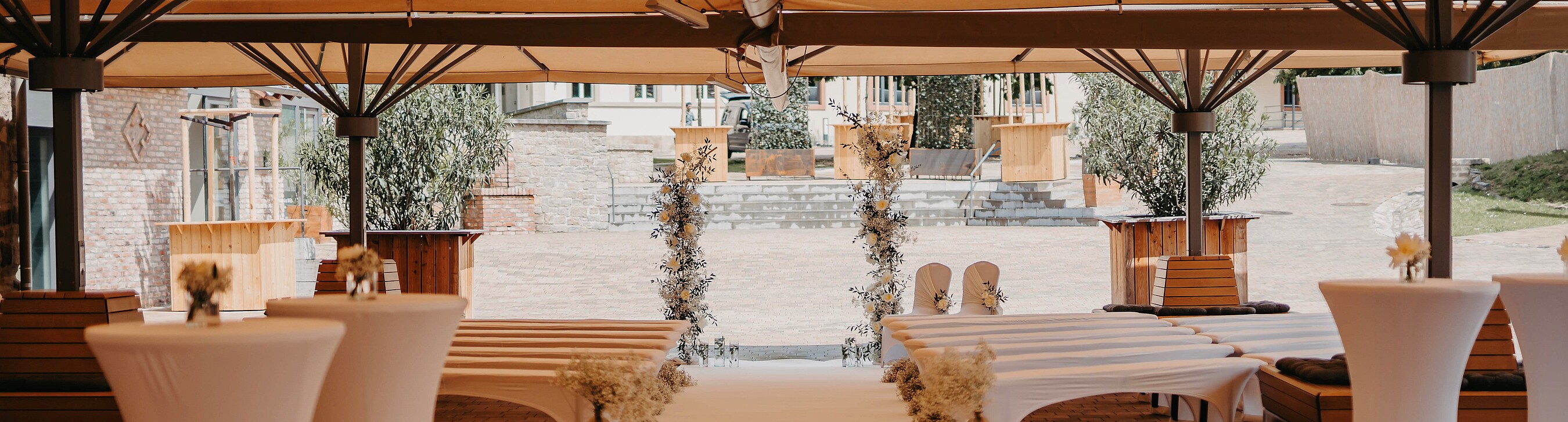 Für eine Outdoor-Trauung im Boho-Stil festlich dekorierter Innenhof von Gut Wöllried, der Hochzeitslocation in Würzburg