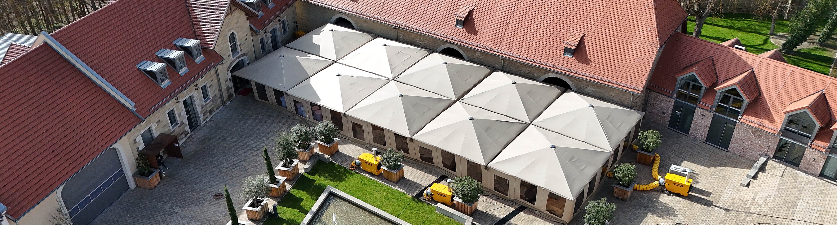 Innenhof der Eventlocation Gut Wöllried mit geschlossener Schirmlösung, um im Außenbereich vom Wetter unabhängig zu sein