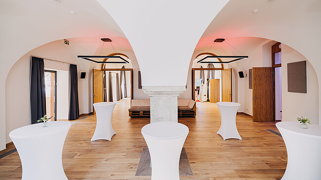 Cocktailtische, moderne Einrichtung und Beleuchtung des Gebäudes "Brennerei" der Würzburger Eventlocation Gut Wöllried